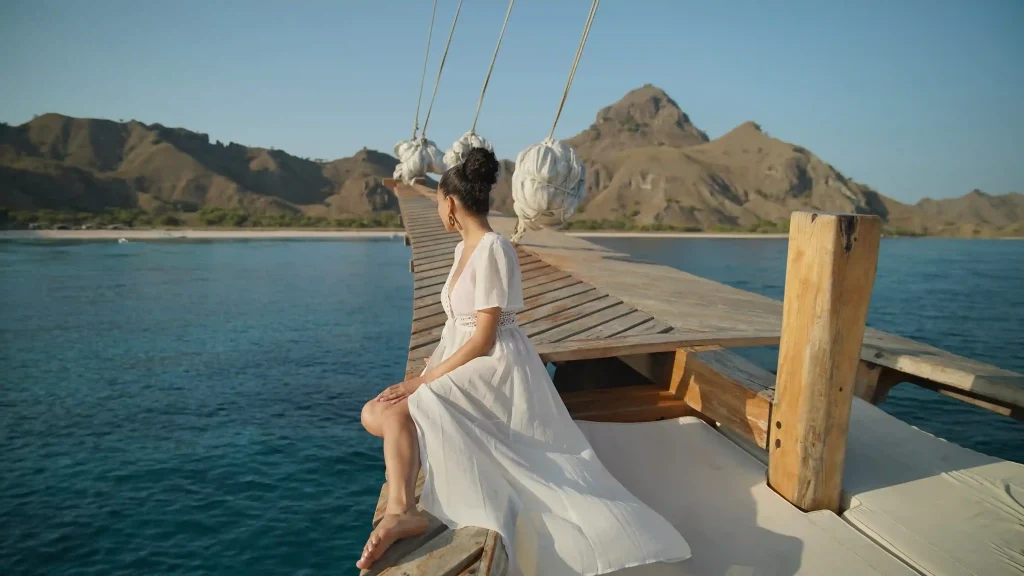 Guest on the deck of a phinisi on a Komodo sailing trip