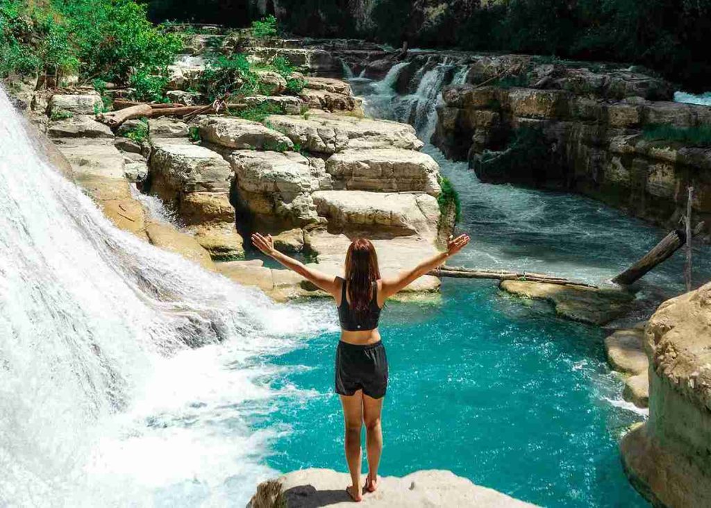 Visitor at the turquoise pools of Tanggedu Waterfall