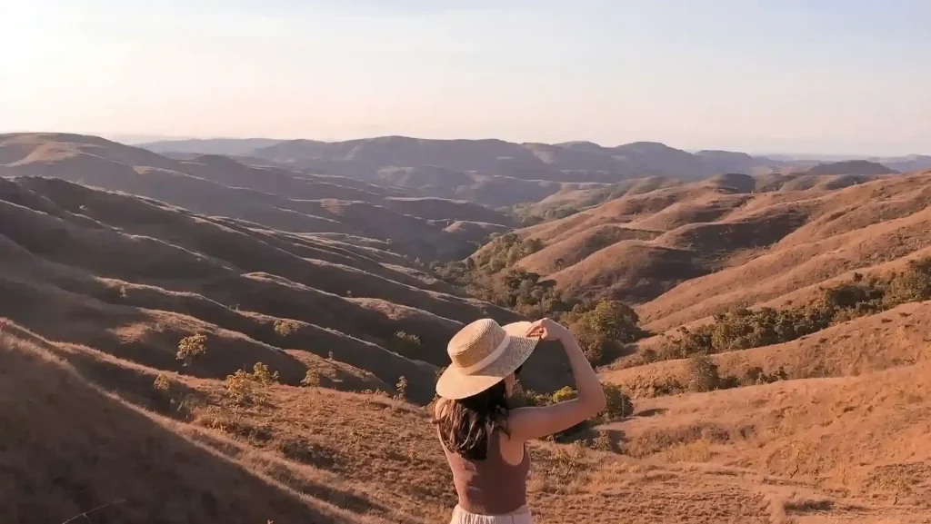Traveller trekking across the hills of Sumba